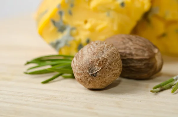 Мускатный орех с двумя кусочками сыра на деревянном столе — стоковое фото
