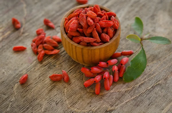 Barberries and goji berries on wooden background — Stock Photo, Image