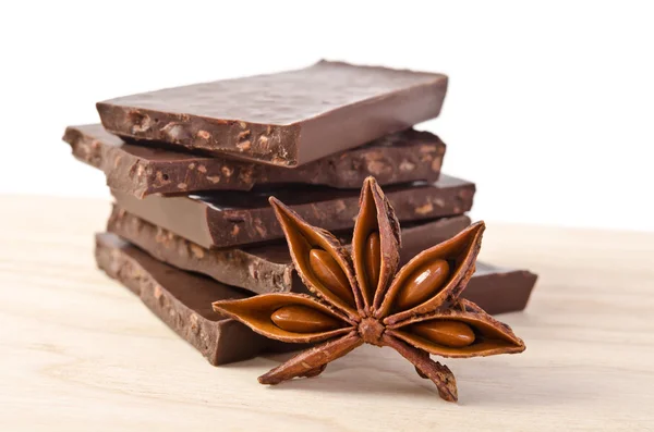 Star of anise  and tower from chocolate  on wooden table — Stock Photo, Image