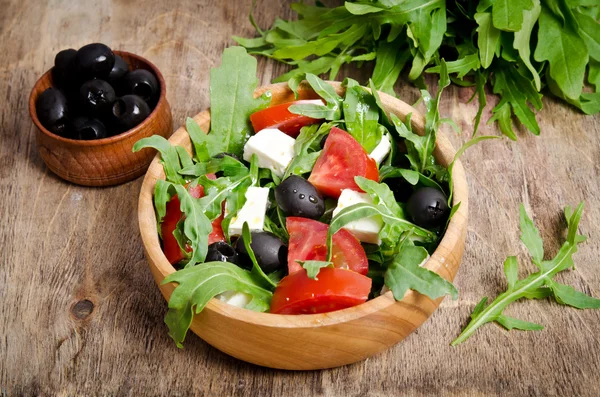 Sallad med tomater och Oliver på trä bakgrund. — Stockfoto