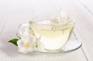 Cam bardak çay ile yasemin beyaz zemin üzerine