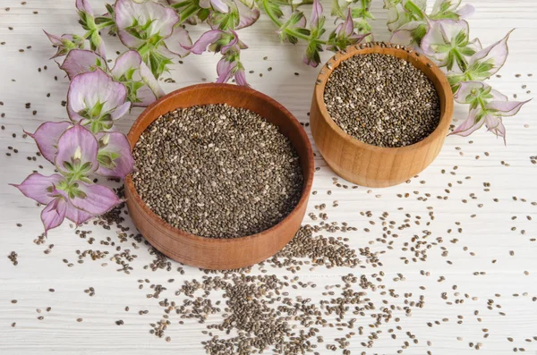 Semilla de chía saludable súper alimento con flor sobre fondo de madera blanca —  Fotos de Stock