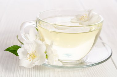 Cam bardak çay ile yasemin beyaz zemin üzerine