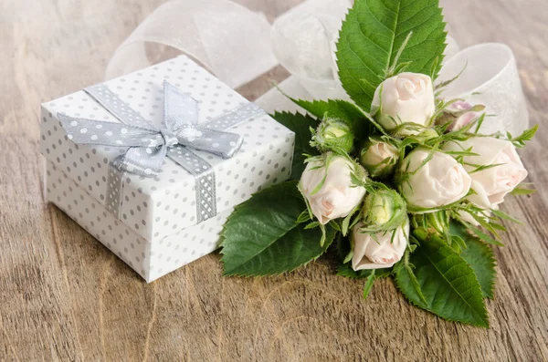 Bouquet van witte rozen en de doos van de gift op houten achtergrond — Stockfoto