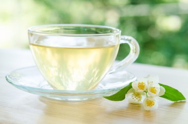 Cam bardak çay ile Yasemin ahşap arka plan üzerinde