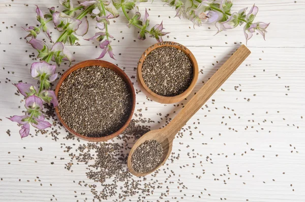 Semilla de chía saludable súper alimento con flor sobre fondo de madera blanca —  Fotos de Stock