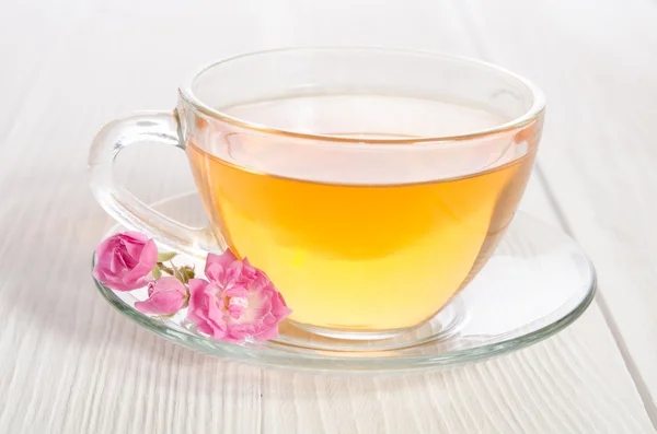 Glas kopje thee met rose op witte houten tafel — Stockfoto