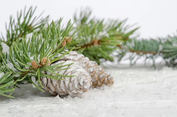 Fondo de pantalla de Navidad con abeto de nieve y piñas —  Fotos de Stock