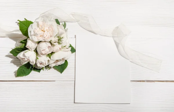 Букет білих троянд на білому столі з порожньою карткою для вас text — стокове фото