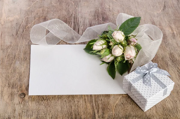 Caja de regalo y rosas blancas con tarjeta vacía para usted texto en madera — Foto de Stock