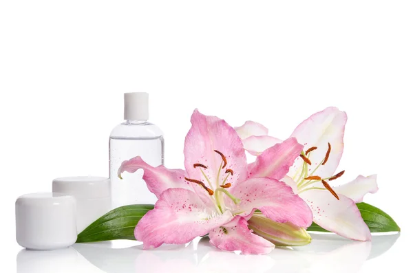 Set cosmético para el cuidado de la piel sobre un fondo blanco con flores li — Foto de Stock