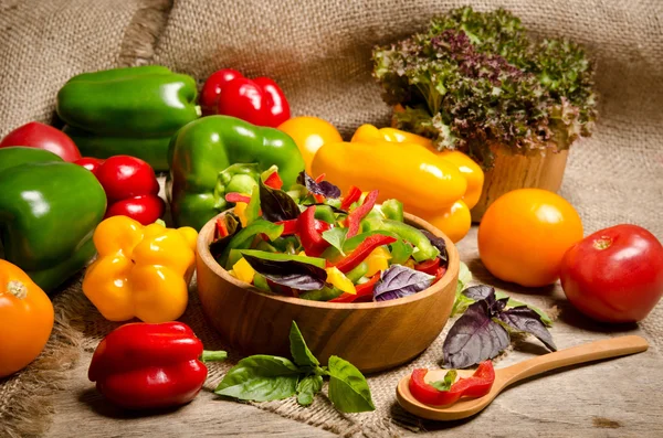 Ensalada de pimiento y albahaca en un tazón de madera y tomate en —  Fotos de Stock