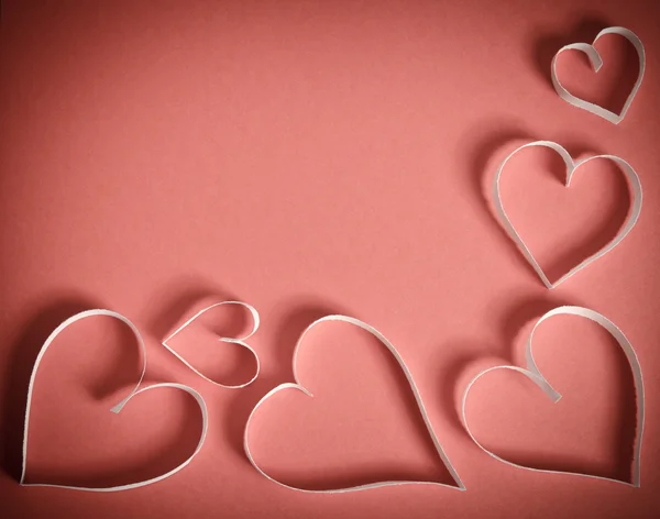 Hearts from white paper lying on a red background.top view — Stock Photo, Image