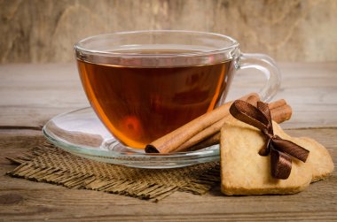 Çerezler-kalpler birlikte ilgili ve bir fincan çay üzerinde ahşap tabl