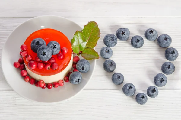 Frame- coração de mirtilo e bolo de frutas em tampo de mesa de madeira — Fotografia de Stock