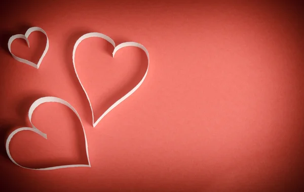 Hearts from white paper lying on a red background.top view — Stock Photo, Image