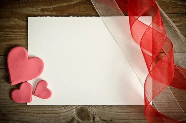 El pedazo de papel acostado con corazones y cintas en un bac de madera —  Fotos de Stock