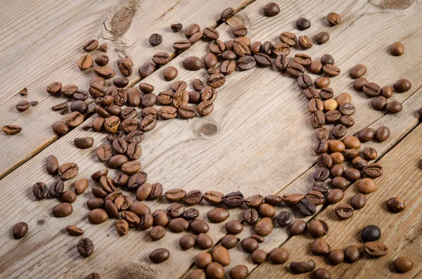 Marco-corazón de granos de café en la mesa de madera — Foto de Stock