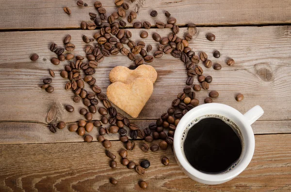 A xícara de café e Frame- coração de grãos de café e dois cozinheiro — Fotografia de Stock