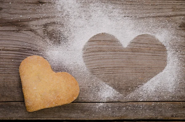 Marca na forma de um coração com açúcar em pó e biscoito-ouvir — Fotografia de Stock
