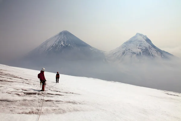 Ploskaya 火山の上部にあるアルピニスト. — ストック写真