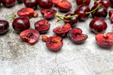 Beton bir masa üzerinde bir yığın bütünü ve yarıya indirilmiş kiraz.