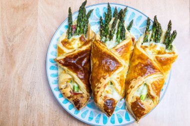 Jambonlu börek ve ahşap masada kuşkonmaz.