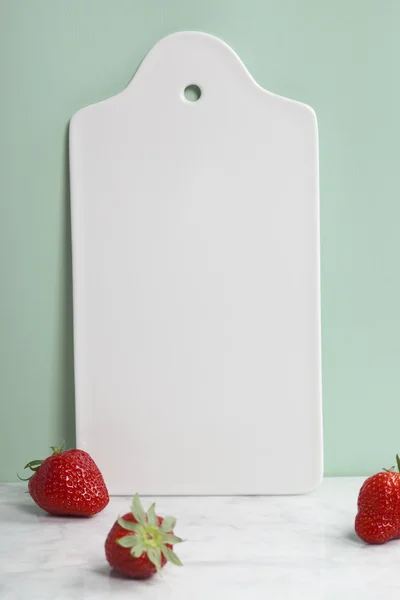 White ceramic serving board and berry over light blue background — Stock Photo, Image