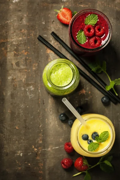 Copos de vários smoothies com palhas e frutos — Fotografia de Stock