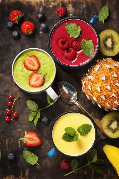 Glazen diverse smoothies met rietjes en vruchten — Stockfoto