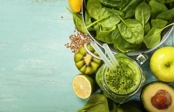 Gezonde groene smoothie en ingrediënten op blauwe achtergrond — Stockfoto