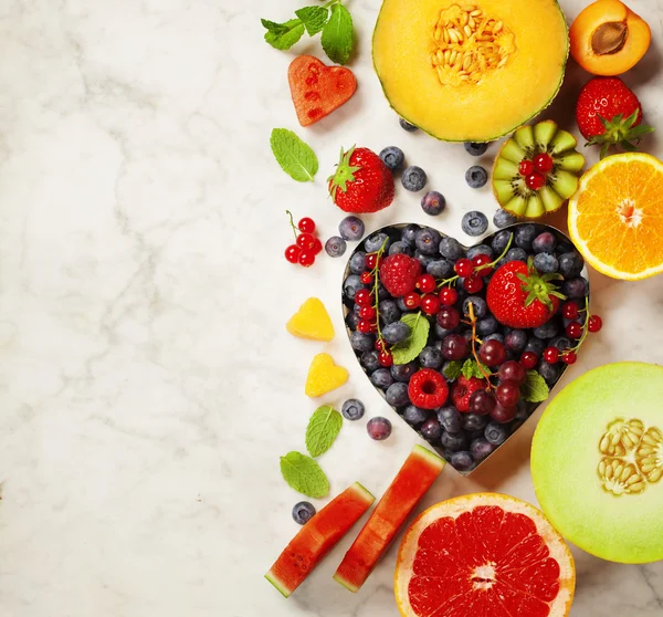 Früchte und Beeren auf weißem Marmor Hintergrund — Stockfoto