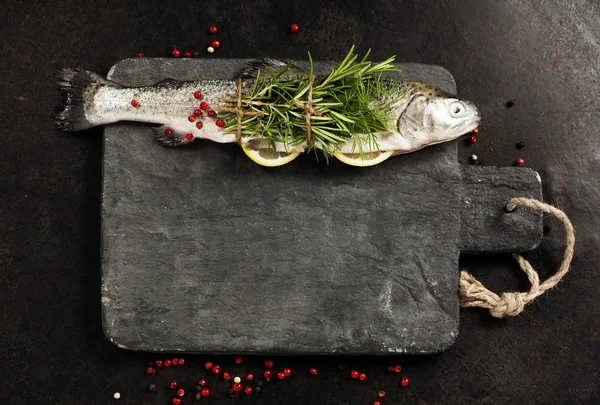 Raw rainbow trout with lemon, herbs and spice — Stock Photo, Image