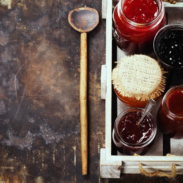 Fruit and berry jam on a rustic background — Stock Photo, Image
