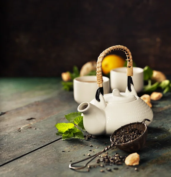Teapot and cups of tea with mint and lemon — Stock Photo, Image