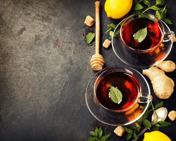 Tazas de té caliente con menta, limón y azúcar —  Fotos de Stock