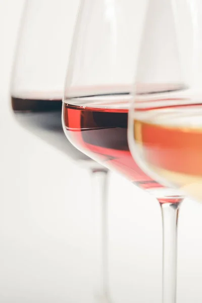 Bicchieri di vino bianco, rosso e rosato su sfondo bianco, da vicino — Foto Stock