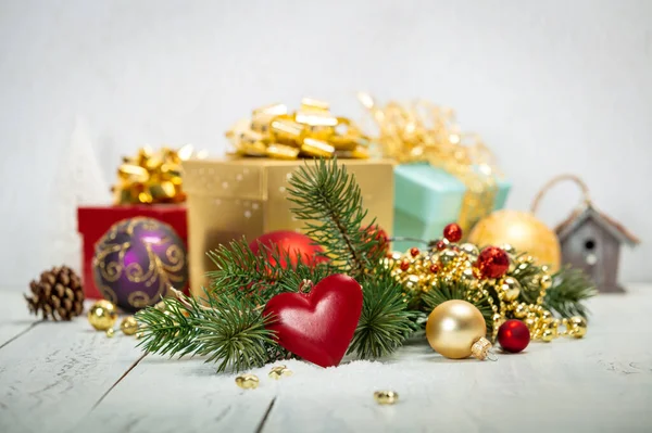 Kompozycja świąteczna na białym tle z pięknymi pudełkami na prezenty, ze złotą wstążką, gałązkami jodły i zabawkami — Zdjęcie stockowe