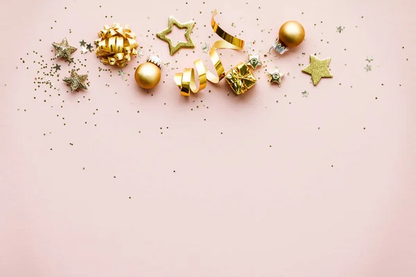 Flat lay de Celebração. Decorações de Natal dourado em fundo rosa — Fotografia de Stock