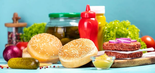 Ингредиенты для приготовления гамбургеров на синем фоне — стоковое фото