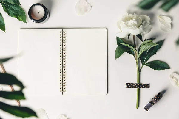 Flat-lay of Beautiful peony flower taped on white background and open notebook — Stock Photo, Image