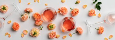 Beyaz arka planda gül şarabı ve güller