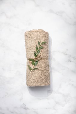 Beyaz mermer arka planda yeşil dal ve SPA havlusu