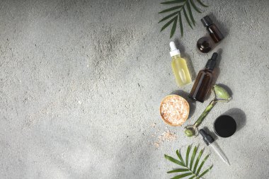 Doğal SPA kozmetik ürünleri arka plan, gerekli yağ şişeleri, deniz tuzu ve masaj ruloları ile kompozisyon, kopyalama alanı