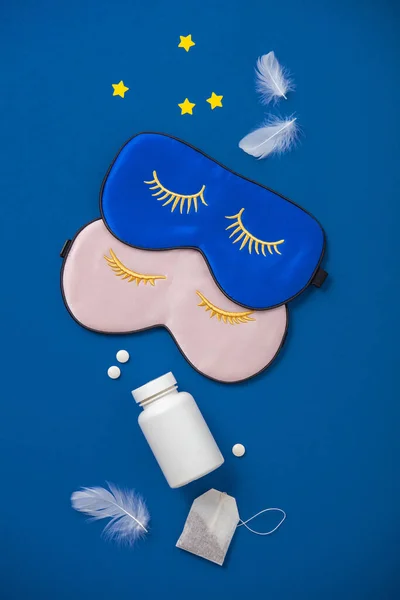 青とピンクの睡眠マスク、青の背景に薬やハーブティー、休息の概念、睡眠の質、良い夜、不眠症、リラクゼーション — ストック写真