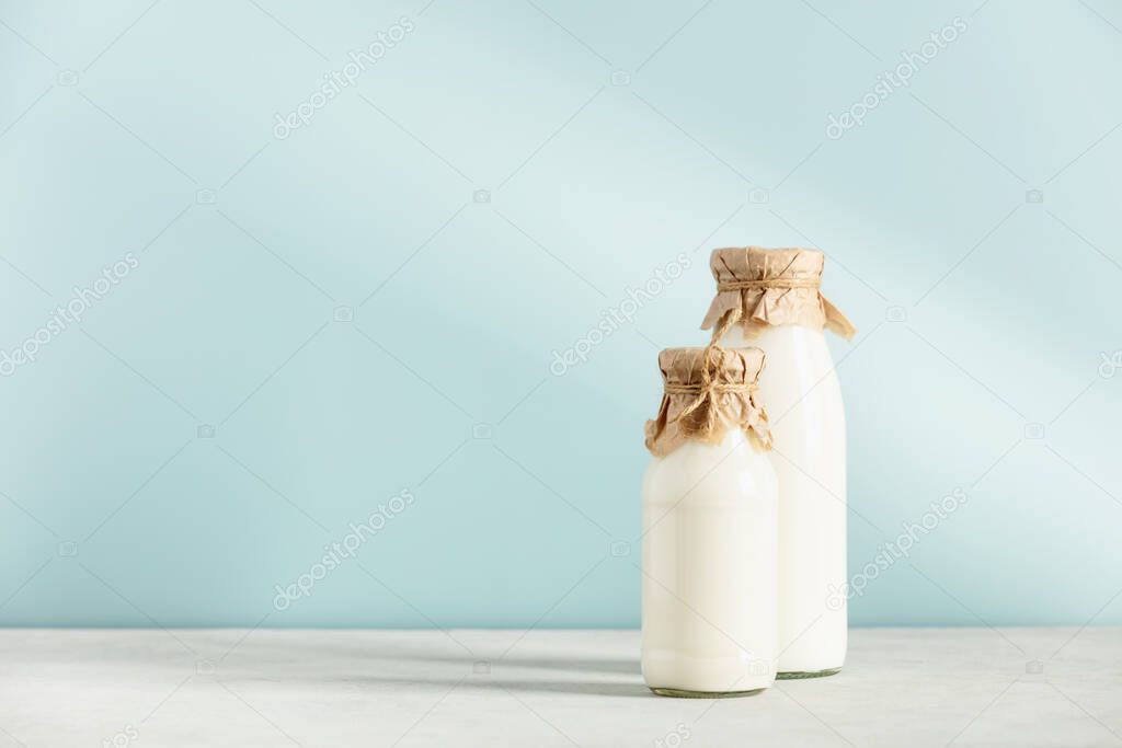 on dairy plant based milk in bottles and ingredients on blue background. Alternative lactose free milk substitute