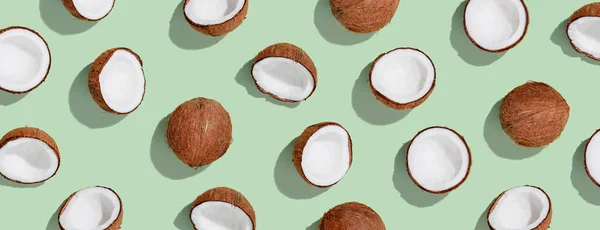 Patroon met rijpe kokosnoten op groene ondergrond. Bovenaanzicht — Stockfoto