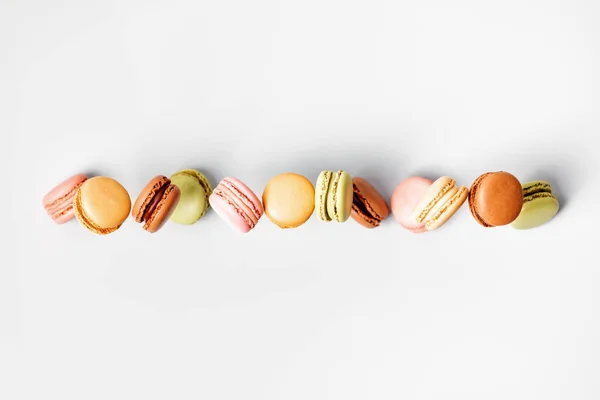 Macarrones o macarrones franceses de color pastel vintage en movimiento que caen sobre fondo gris — Foto de Stock