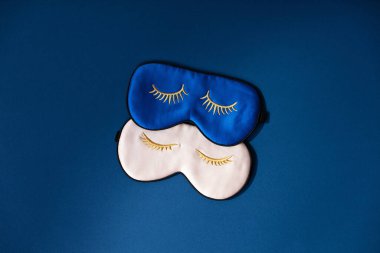 Mavi arka planda iki uyku maskesi, dinlenme konsepti, uyku kalitesi, iyi geceler, uykusuzluk, rahatlama