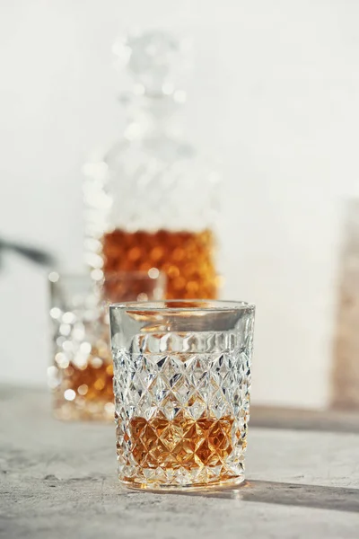 Glasses of whiskey with ice cubes and carafe close up — Stock Photo, Image